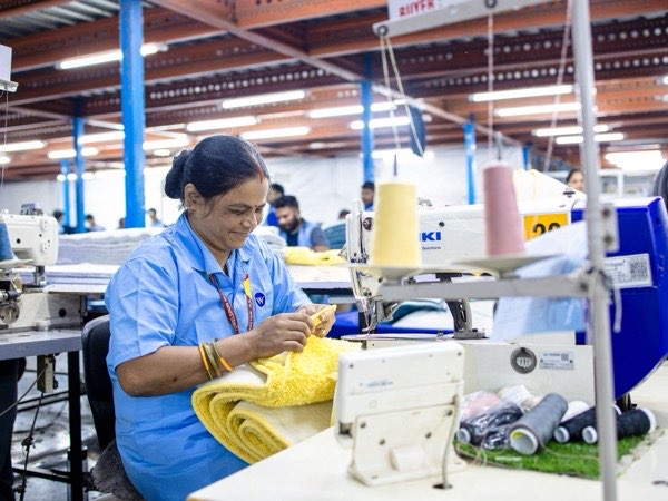 Machine operator sewing a garment on an industrial machine