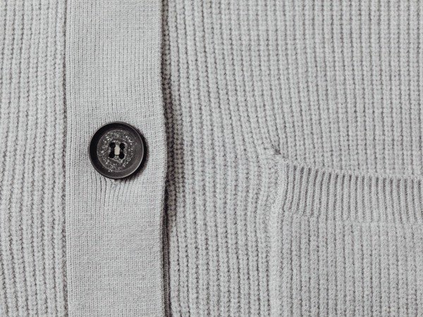 Close-up of a knitted cardigan showing stitch and button detail